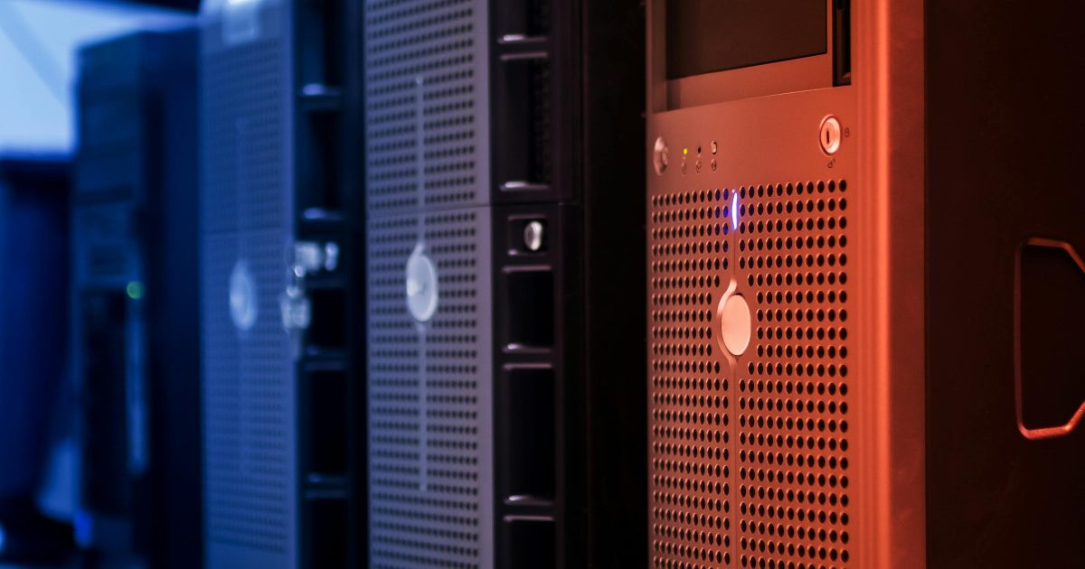 Close-up of tower servers in a data center with blue and red lighting.