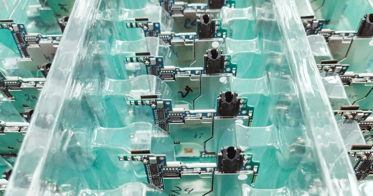 Detailed view of organized electronic circuit boards in a production setting.