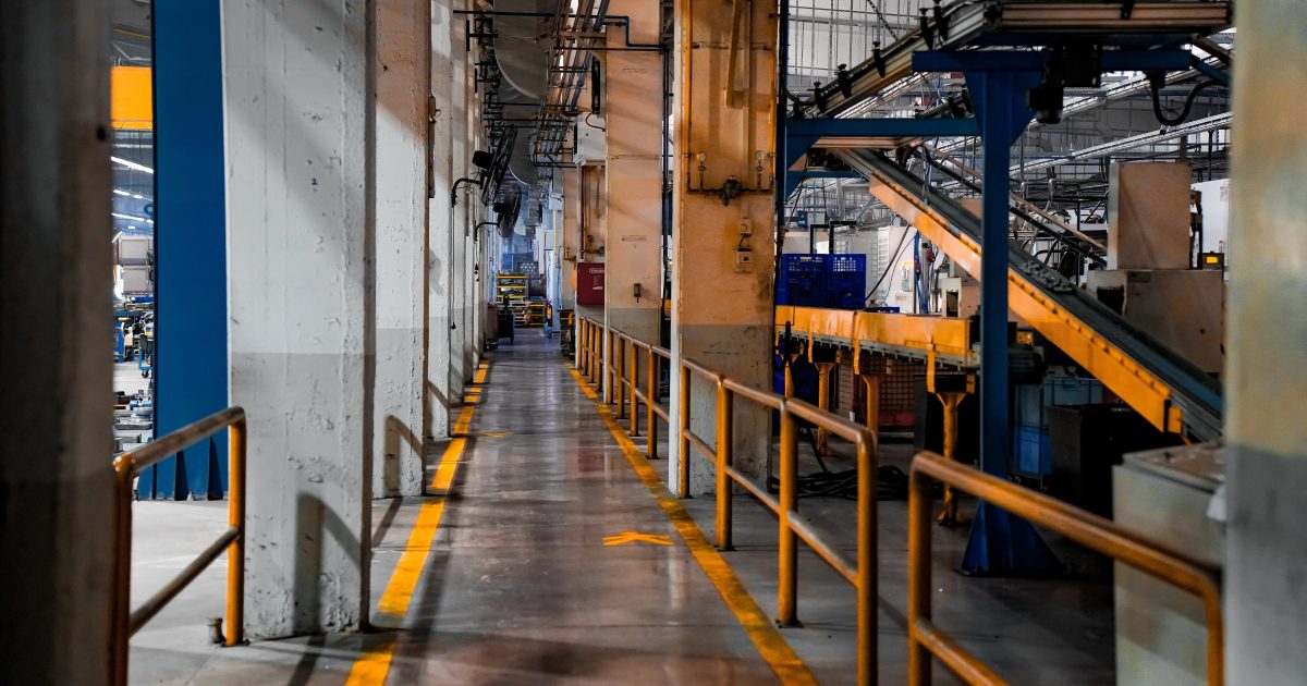 Wide view of a modern factory interior showcasing industrial machinery and conveyor systems.