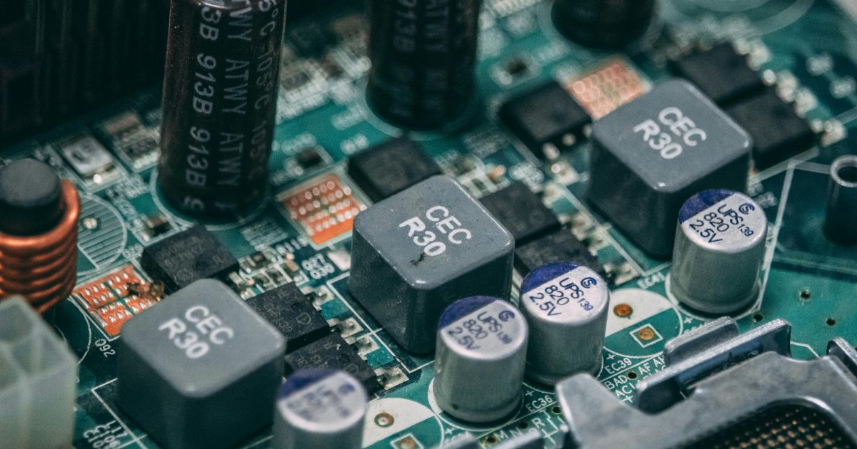 Detailed view of electronic components on a circuit board showcasing capacitors and semiconductors.