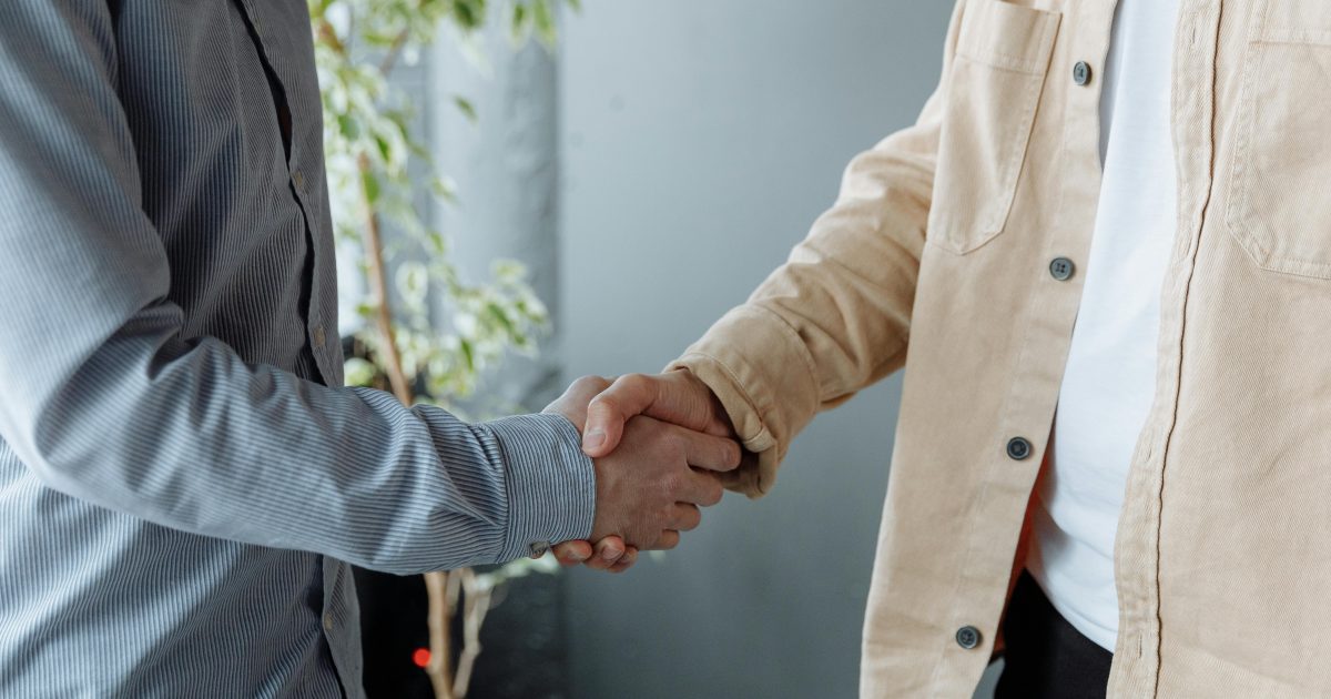 A close-up image of two businesspeople shaking hands in an office environment symbolizing agreement and partnership.