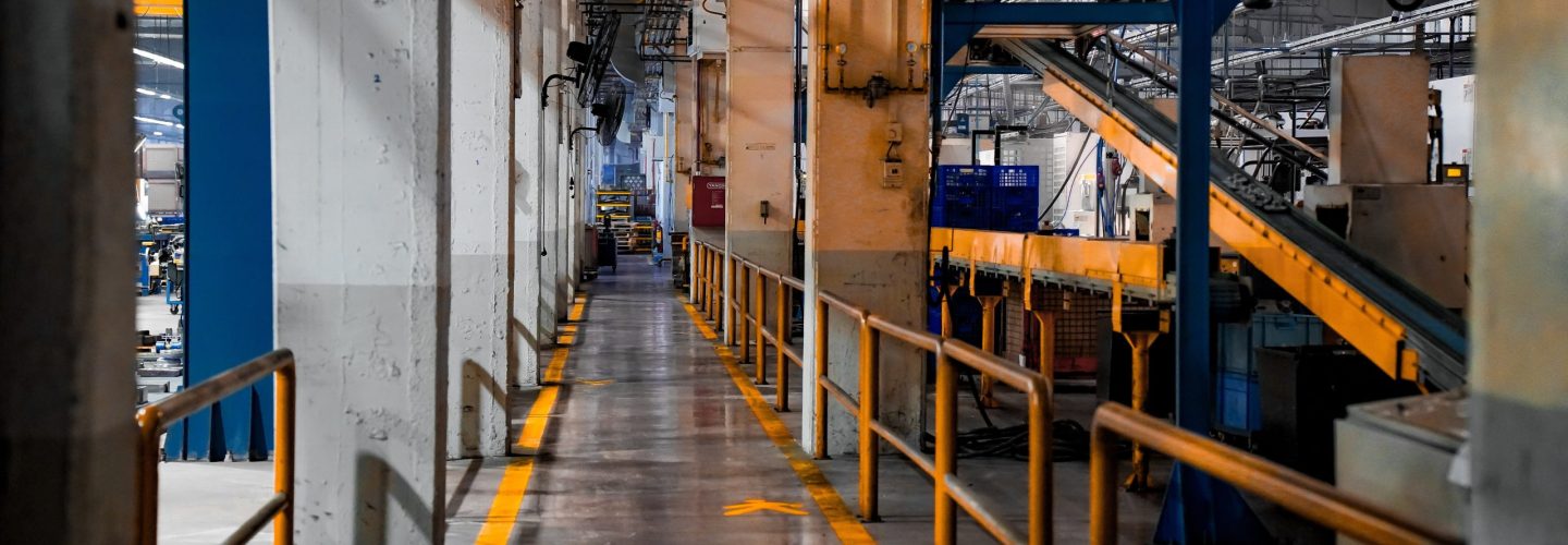 Wide view of a modern factory interior showcasing industrial machinery and conveyor systems.