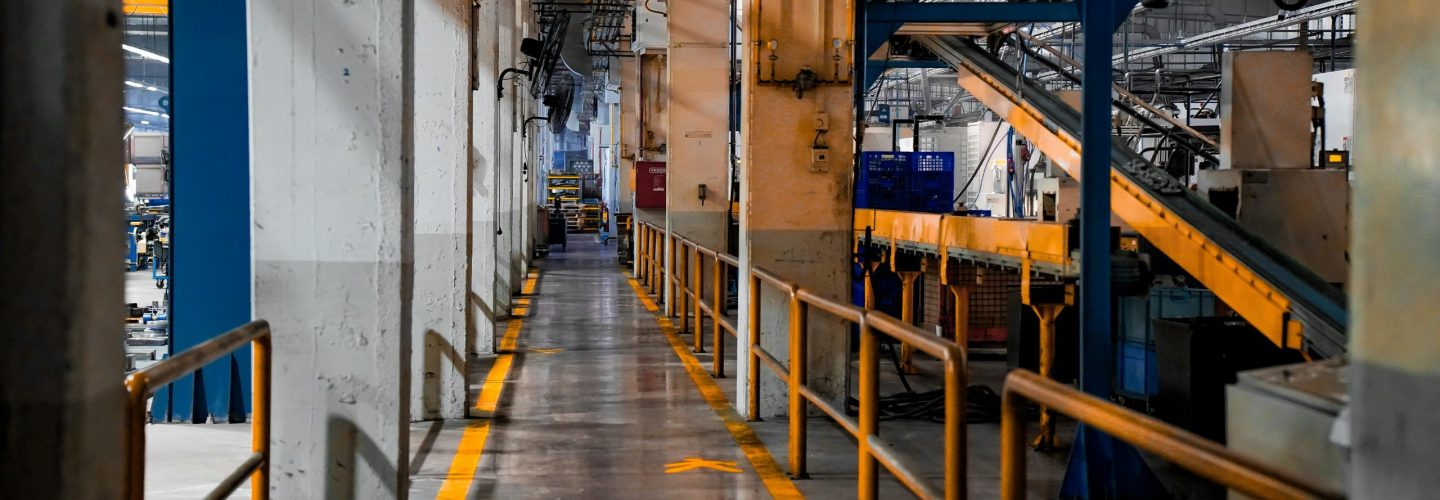 Wide view of a modern factory interior showcasing industrial machinery and conveyor systems.