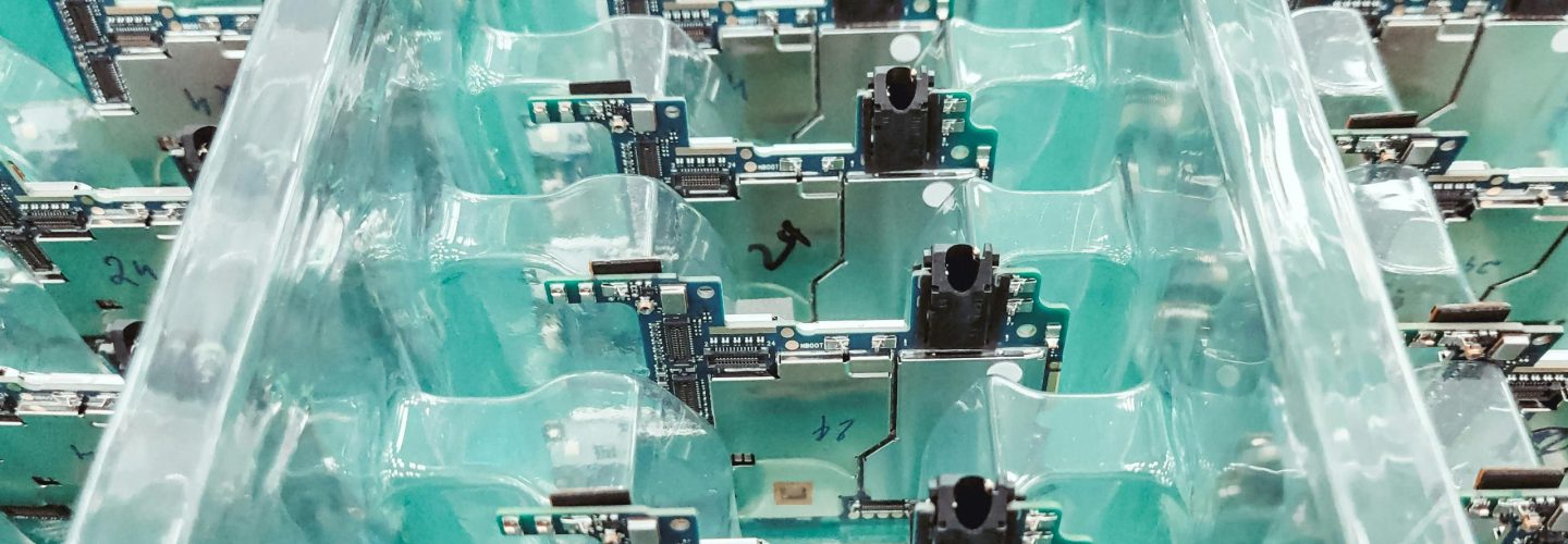 Detailed view of organized electronic circuit boards in a production setting.